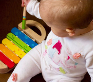 infant girl playing with an educational toy