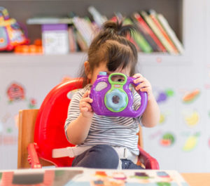 female toddler playing with an educational toy in a preschool classroom